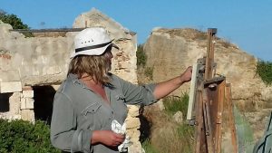 Photograph of Hugo Galerie artist Lucy MacGillis painting in the Italian countryside.